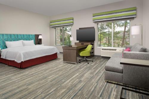 a hotel room with a bed and a desk and a tv at Hampton Inn & Suites Lexington in Lexington