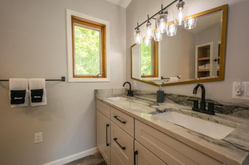 a bathroom with a sink and a mirror at Modern, Sleeps 6, Amazing Views in Maggie Valley