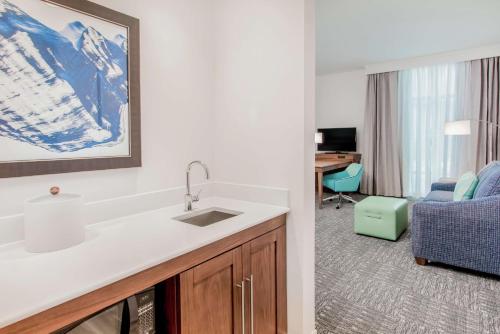 a kitchen with a sink and a desk in a room at Hampton Inn & Suites Panama City Beach-Beachfront in Panama City Beach