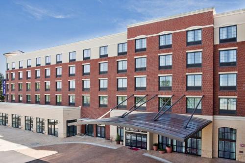 a large red brick building with a staircase in front at Hampton Inn & Suites Chapel Hill/Carrboro in Chapel Hill