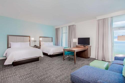 a hotel room with two beds and a desk at Hampton Inn & Suites Panama City Beach-Beachfront in Panama City Beach