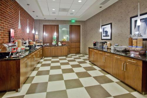 a large kitchen with wooden cabinets and a checkered floor at Hampton Inn & Suites Chapel Hill/Carrboro in Chapel Hill