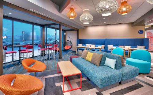 a waiting room with a couch and tables and chairs at Tru By Hilton St. George in St. George