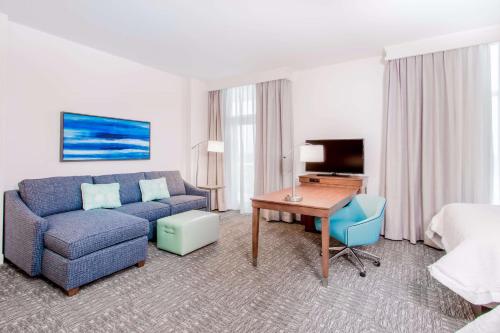 a living room with a couch and a desk in a hotel room at Hampton Inn & Suites Panama City Beach-Beachfront in Panama City Beach