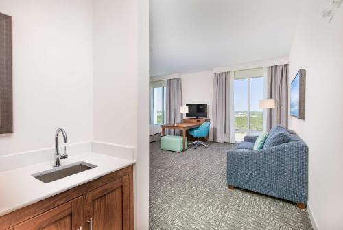 a kitchen and a living room with a sink and a couch at Hampton Inn & Suites Panama City Beach-Beachfront in Panama City Beach