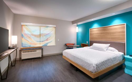 um quarto com uma cama e uma parede azul em Tru By Hilton St. George em St. George