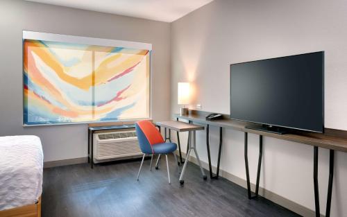 a room with a desk with a television and a bed at Tru By Hilton St. George in St. George
