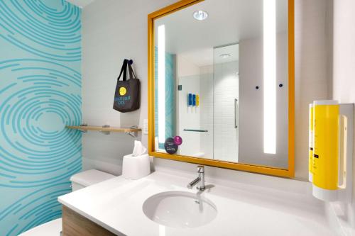 a bathroom with a sink and a mirror at Tru By Hilton St. George in St. George