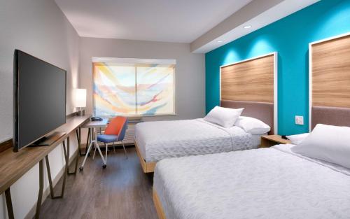 a hotel room with two beds and a desk with a tv at Tru By Hilton St. George in St. George