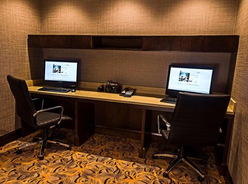 two computers sitting on a desk with two chairs at Hampton Inn by Hilton Ottawa Airport in Ottawa