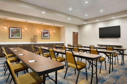 a conference room with tables and chairs and a flat screen tv at Hampton Inn Salt Lake City Cottonwood in Holladay