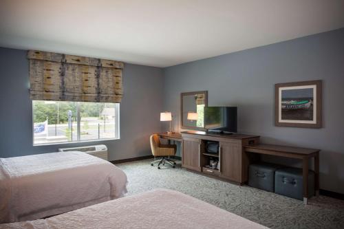 a bedroom with a bed and a desk with a television at Hampton Inn Atlantic City/Absecon, NJ in Absecon