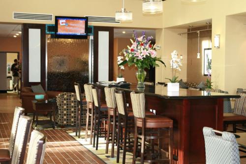 a bar in a restaurant with chairs and flowers at Hampton Inn & Suites Dumas in Dumas