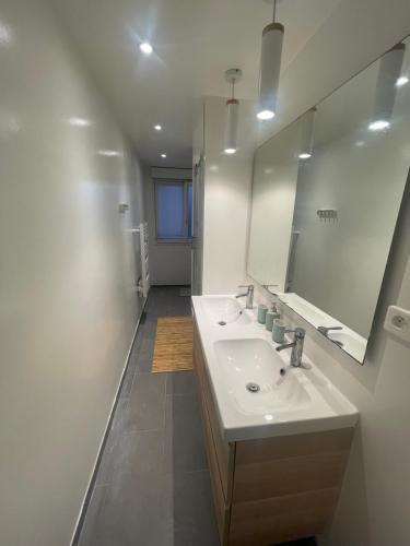 uma casa de banho branca com um lavatório e um espelho em Big flat Brest em Brest