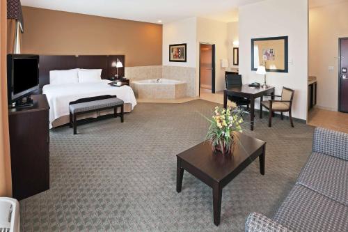 a hotel room with a bed and a living room at Hampton Inn & Suites Dumas in Dumas