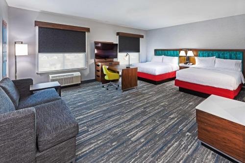 キャニオンにあるHampton Inn & Suites Canyon, Txのベッド2台とソファが備わるホテルルームです。