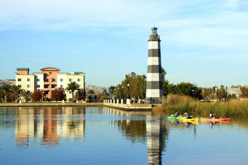 people in kayaks on the water near a lighthouse at Hampton Inn & Suites Suisun City Waterfront in Suisun City