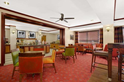 a restaurant with chairs and tables and a bar at Hampton Inn Athens in Athens