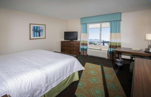 a hotel room with a bed and a desk and a window at Hampton Inn & Suites Suisun City Waterfront in Suisun City