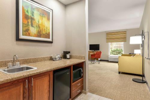 a kitchen with a sink and a living room at Hampton Inn Athens in Athens