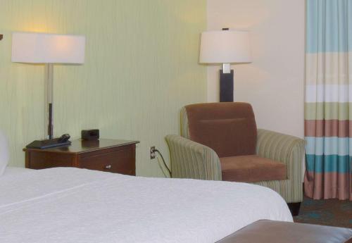 a hotel room with a bed and a chair at Hampton Inn & Suites Suisun City Waterfront in Suisun City