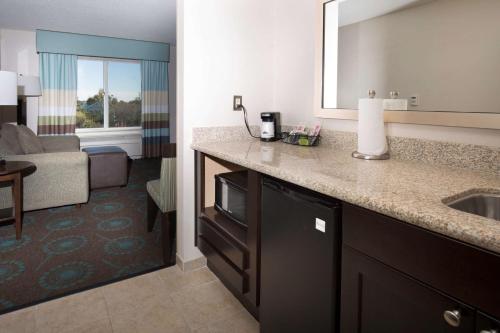 a hotel bathroom with a sink and a living room at Hampton Inn & Suites Suisun City Waterfront in Suisun City