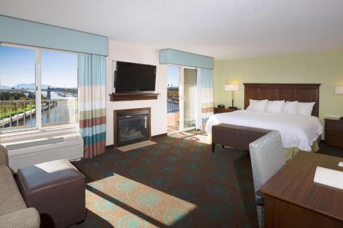 Hampton Inn & Suites Suisun City Waterfront في Suisun City: غرفة فندقية بها سرير وموقد