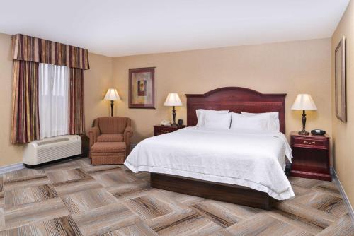 a hotel room with a bed and a chair at Hampton Inn & Suites Boise-Meridian in Meridian