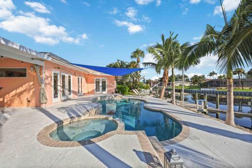 uma piscina com palmeiras e uma casa em Experience the Ultimate Waterfront Getaway! em Bradenton