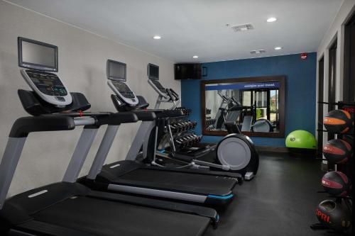 a gym with several tread machines and a mirror at Hampton Inn Bartlesville in Bartlesville