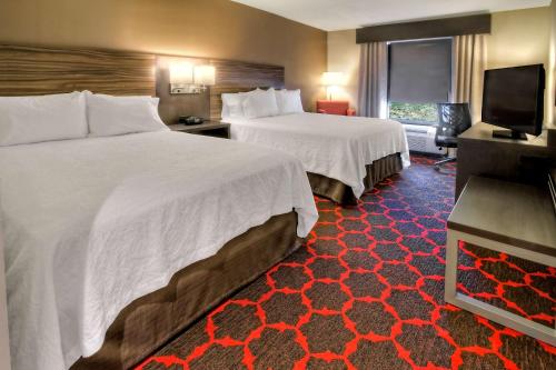 a hotel room with two beds and a flat screen tv at Hampton Inn Cookeville in Cookeville