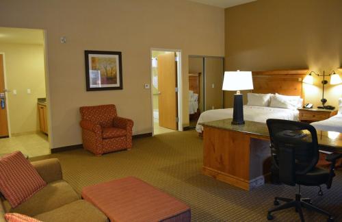 a hotel room with a bed and a desk and chair at Hampton Inn & Suites Buffalo in Buffalo