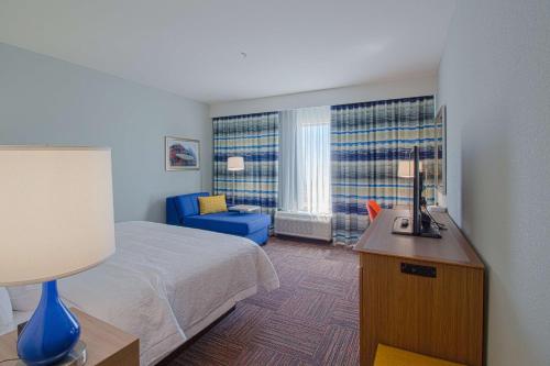 克雷斯特维尤Hampton Inn Crestview South I-10, Fl的一间带床和蓝色椅子的酒店房间