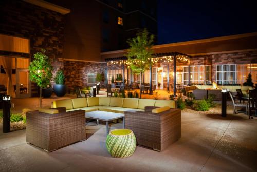 a patio with a couch and a table and chairs at Hilton Garden Inn Broomfield Boulder in Broomfield