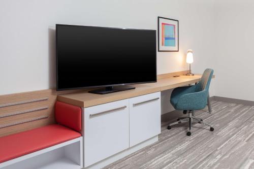 an office with a desk with a tv and a chair at Hilton Garden Inn Broomfield Boulder in Broomfield