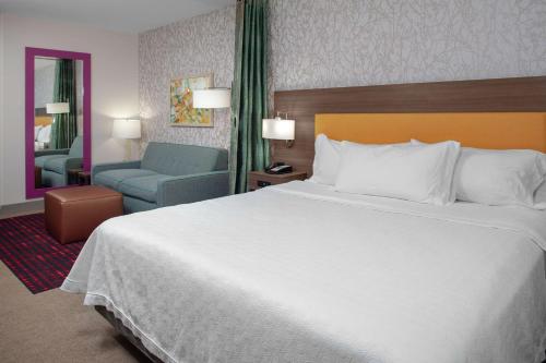 a hotel room with a large bed and a chair at Home2 Suites By Hilton Denver South Centennial Airport in Centennial