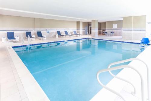 a large swimming pool with blue water and chairs at Homewood Suites By Hilton Broomfield Boulder in Broomfield