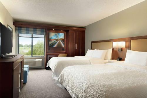 a hotel room with two beds and a television at Hampton Inn West Des Moines Lake Drive in West Des Moines
