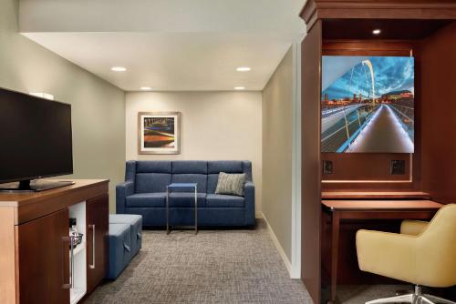 a living room with a blue couch and a flat screen tv at Hampton Inn West Des Moines Lake Drive in West Des Moines