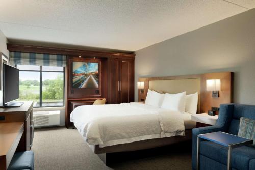 ein Hotelzimmer mit einem Bett und einem TV in der Unterkunft Hampton Inn West Des Moines Lake Drive in West Des Moines