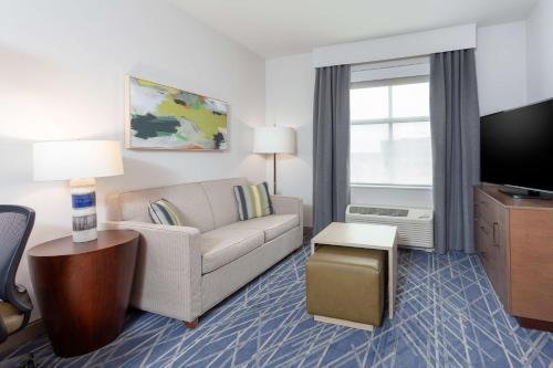 a living room with a couch and a tv at Homewood Suites By Hilton Broomfield Boulder in Broomfield