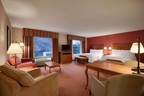 a hotel room with two beds and a desk at Hampton Inn & Suites East Hartford in East Hartford