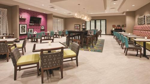 a restaurant with tables and chairs and a dining room at Hampton Inn Kearney in Kearney