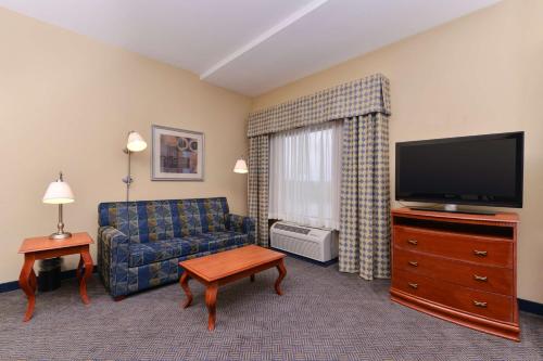 a living room with a couch and a flat screen tv at Hampton Inn Evanston in Evanston