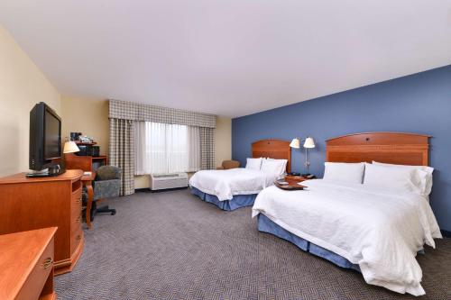 a hotel room with two beds and a television at Hampton Inn Evanston in Evanston