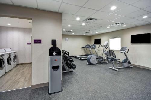 a room with a gym with machines and a bottle of wine at Home2 Suites By Hilton Fort Worth Fossil Creek in Fort Worth