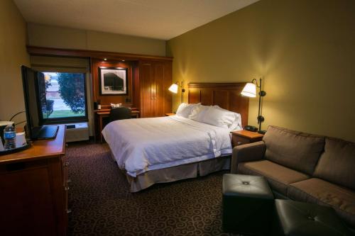 a hotel room with a bed and a couch at SPX Hotel Green Bay in Green Bay