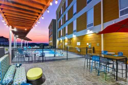 a patio with a table and chairs and a pool at Home2 Suites By Hilton Hot Springs in Hot Springs