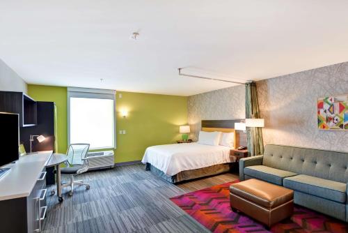 Habitación de hotel con cama y sofá en Home2 Suites By Hilton Hot Springs, en Hot Springs