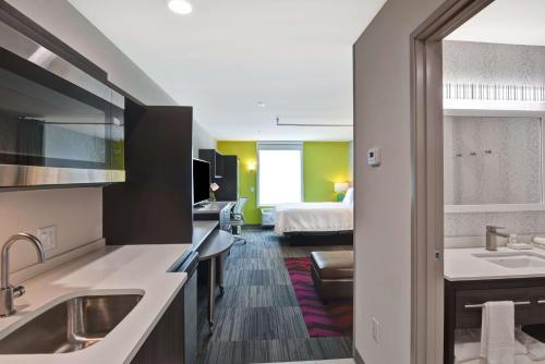 a hotel room with a bed and a bathroom at Home2 Suites By Hilton Hot Springs in Hot Springs